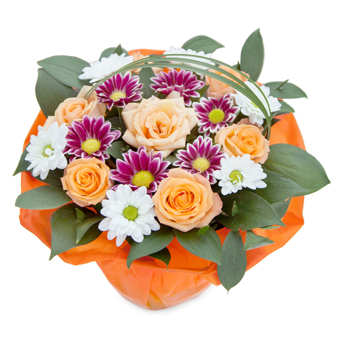 Seemingly gathered on a clear morning and bathed in gentle light, this lush bouquet evokes the welcoming atmosphere of East Finchley with its harmonious blend of hues and textures. The arrangement features sumptuous roses that traverse the colour spectrum from soft peach to vibrant orange, each bloom unfolding with sophisticated grace at the centre. Scattered among them are cheerful clusters of chrysanthemums-some bearing snowy white petals and lively green eyes reminiscent of open spaces like Cherry Tree Wood, while others feature rich magenta and deep purple tones that circle around lime-green discs for added visual drama. Dark green, broad-leafed foliage, possibly ruscus, supports the blooms and forms a verdant, grounding base, paralleling the leafy borders of local parks. Wisps of bright green bear grass loop artfully above the arrangement, providing gentle movement and a modern flourish. Encasing the bouquet, a crinkled wrap of vivid orange cellophane mirrors the exuberant palette within, signifying both celebration and careful preparation. This bouquet, hand-tied and crafted with the expertise found at East Finchley Flowers, carries an uplifting message-whether as a thoughtful birthday present, a show of appreciation, or simply an elegant way to enhance an East Finchley living room. The interplay of texture, colour, and artisanal skill infuses the arrangement with both local character and joyful energy, perfect for sharing sentiments across the community.