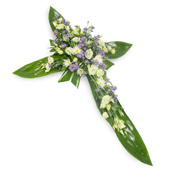 Crafted with careful restraint and photographed from a soft overhead angle against a plain white backdrop, this floral cross balances structure and softness to express reverent remembrance. The foundation is composed of broad, vibrant tropical leaves-Ti leaves or similar-laid to form the cross's arms; their glossy surfaces and clear central veins create a steady, verdant frame that anchors the softer floral clusters. Centered where the vertical and horizontal meet are cream and white lisianthus, their ruffled petals folding inward like small cupped prayers, accompanied by compact white chrysanthemum blooms that bring gentle brightness and texture. Interspersed throughout are tiny sprays of lavender-hued limonium or aster, a delicate wash of dusky purple that adds visual depth and a subtle breath of colour without disturbing the arrangement's calm. Slim, finer greens are woven through the blooms, softening edges and giving the impression of quiet movement, as if a light breeze passed through a chapel garden. The neutral, soft lighting highlights the interplay of waxy leaf sheen and feathery petal edges and suggests a faint green, floral scent-modest, comforting. As a traditional sympathy piece, this cross is suited to funeral services, wakes or memorials and resonates with faith and peaceful reflection. From the perspective of a local florist in East Finchley, this design sits well in chapels along the High Road and at small memorials near Fortis Green, offering a composed and compassionate expression of condolence crafted with respectful intent.
