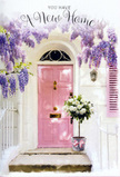 A softly painted pink doorway in East Finchley becomes a tender symbol of homecoming in this image, where every detail feels considered and comforting. The front door, in a muted blush tone, glows gently against smooth whitewashed walls, inviting the eye toward the threshold. A single shutter, painted in the same gentle shade of pink, is slightly ajar, giving the impression of a breeze moving lazily through open windows and quiet rooms inside. Overhead, abundant wisteria trails down in long, floral curtains, each cluster composed of tiny lavender and lilac blossoms that gather into cascading garlands. These tumbling flowers frame the door with a sense of romance and create a soft canopy reminiscent of leafy streets leading toward East Finchley station in late spring. On the step sits a simple, grey metal bucket carefully transformed into a welcoming floral arrangement. It overflows with creamy white roses, each one plush and full, petals curling outward in generous spirals. Threads of soft-green foliage weave between the roses, providing depth, texture, and a gentle contrast to the pale blooms. Encircling the base of the bucket is a pale pink ribbon, tied in a relaxed but intentional bow that mirrors the colour of the door and adds a touch of sweetness. Dappled light filters through the wisteria canopy, scattering subtle shadows across the doorstep and highlighting the curves of each rose petal. The resulting atmosphere is calm, hopeful, and quietly joyful, like the first evening in a new home when everything feels possible. It's an image that suits a new home card or a housewarming bouquet for East Finchley residents, capturing the sense that this doorway is ready to welcome stories, laughter, and everyday life within.